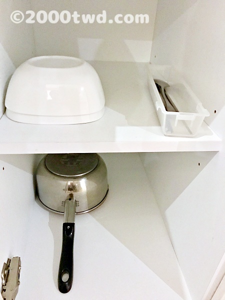 戸棚の中の食器とカトラリーと片手鍋